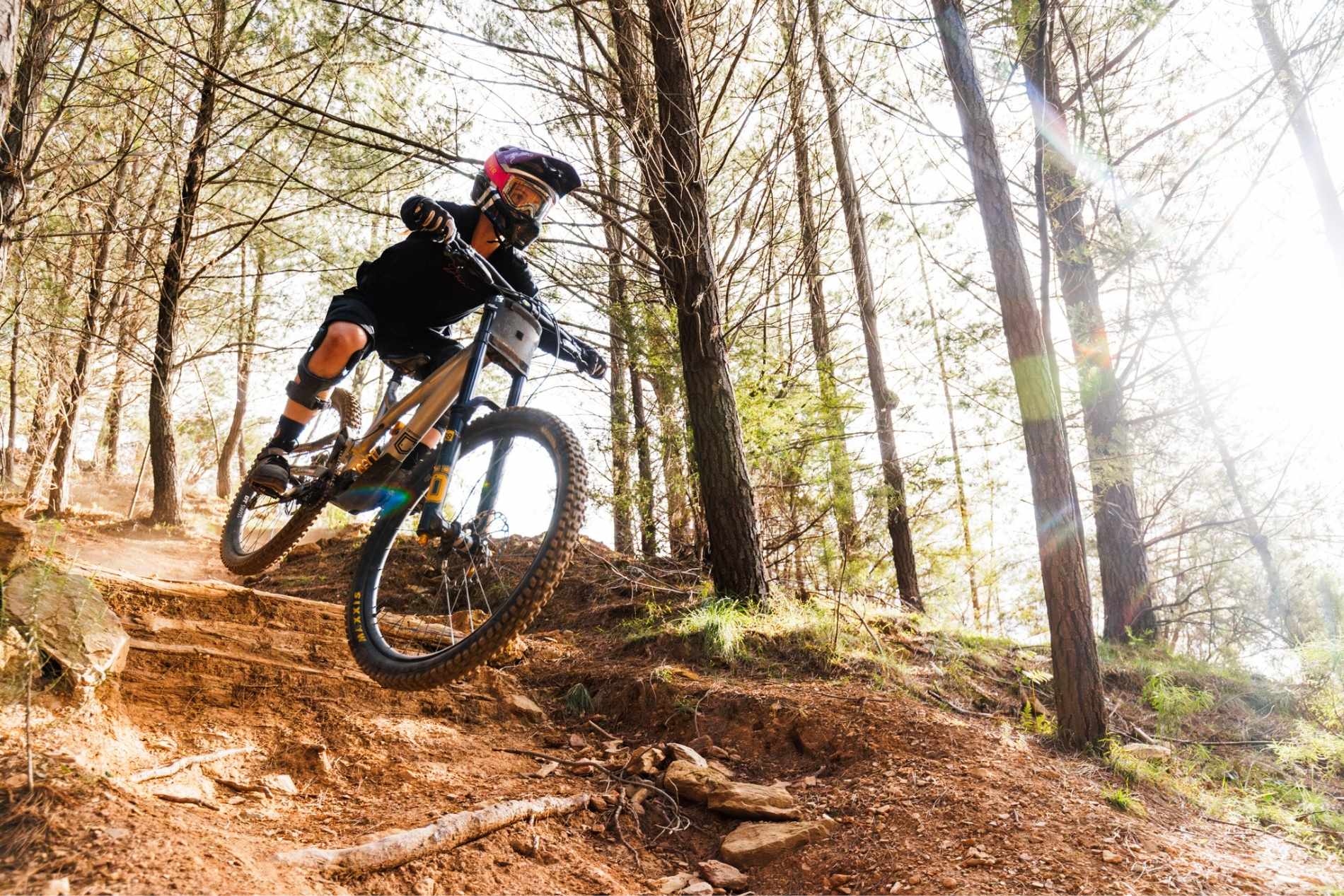 Rider with protective equipment and bicycle at mystic bike park in bright