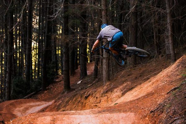Rider jumping on mountain bike in a bike park Mystic Bright Victoria