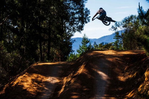 Rider jumping dirt jump at Mystic Bike park in Bright Victoria