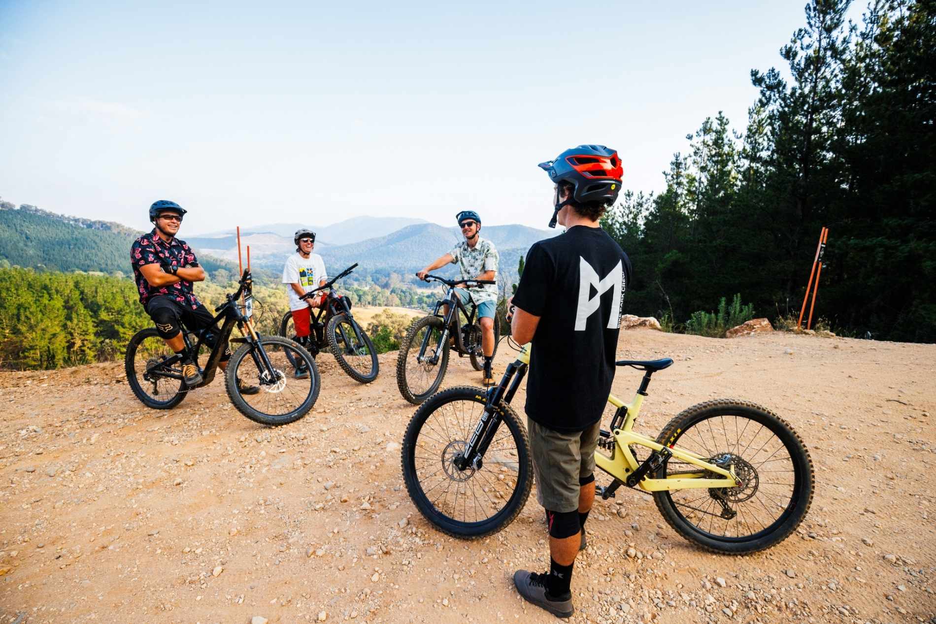 Bike Instructor providing bike school lessons to 3 other riders with mountain backdrop of Bright victoria